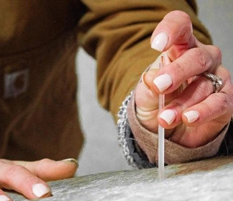 A close up of a person holding a needle in their hand