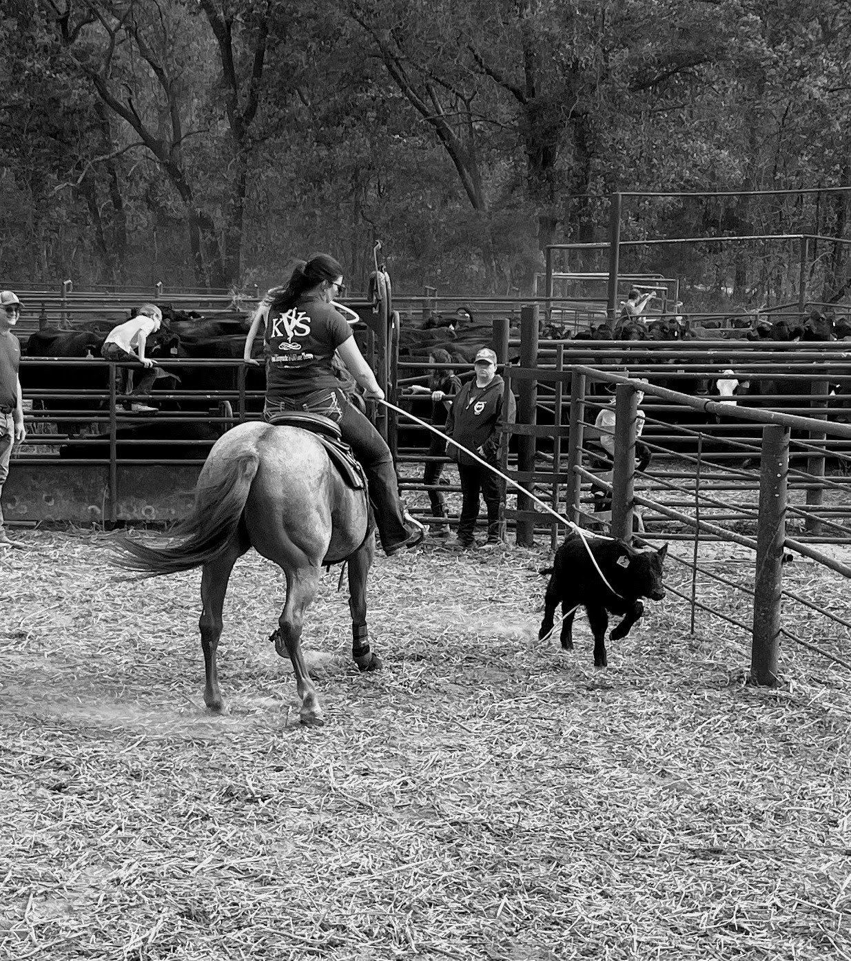 A black and white photo of a woman riding a horse