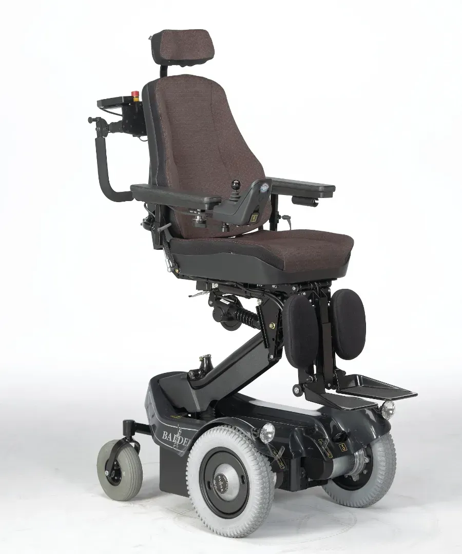 Brun og sort el-kørestol med nakkestøtte, armlæn og benstøtter.