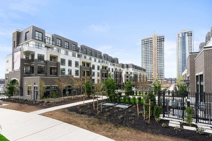 Modern apartment buildings with landscaped courtyard and high-rise towers in the background