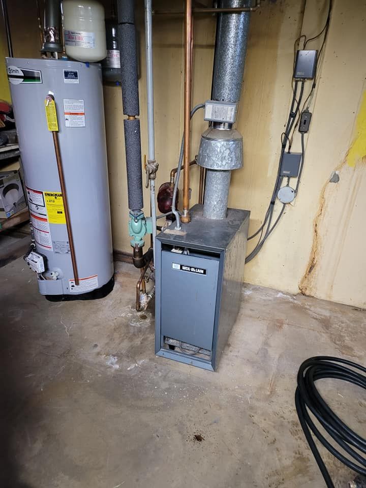 A water heater and a gas boiler are in a basement.