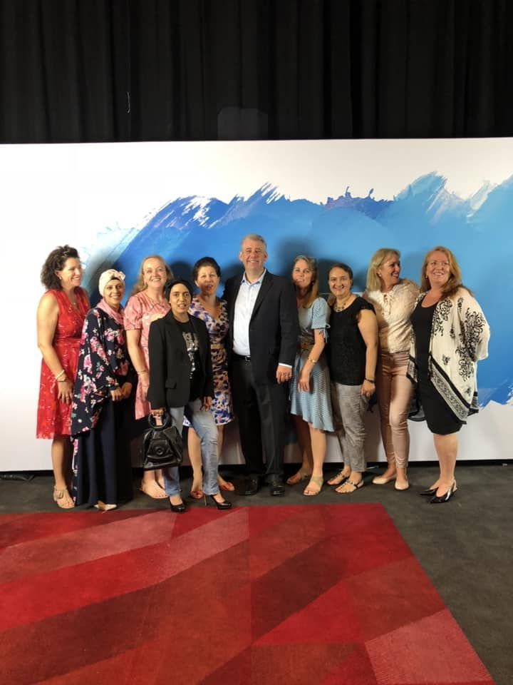 A group of people are posing for a picture in front of a wall.