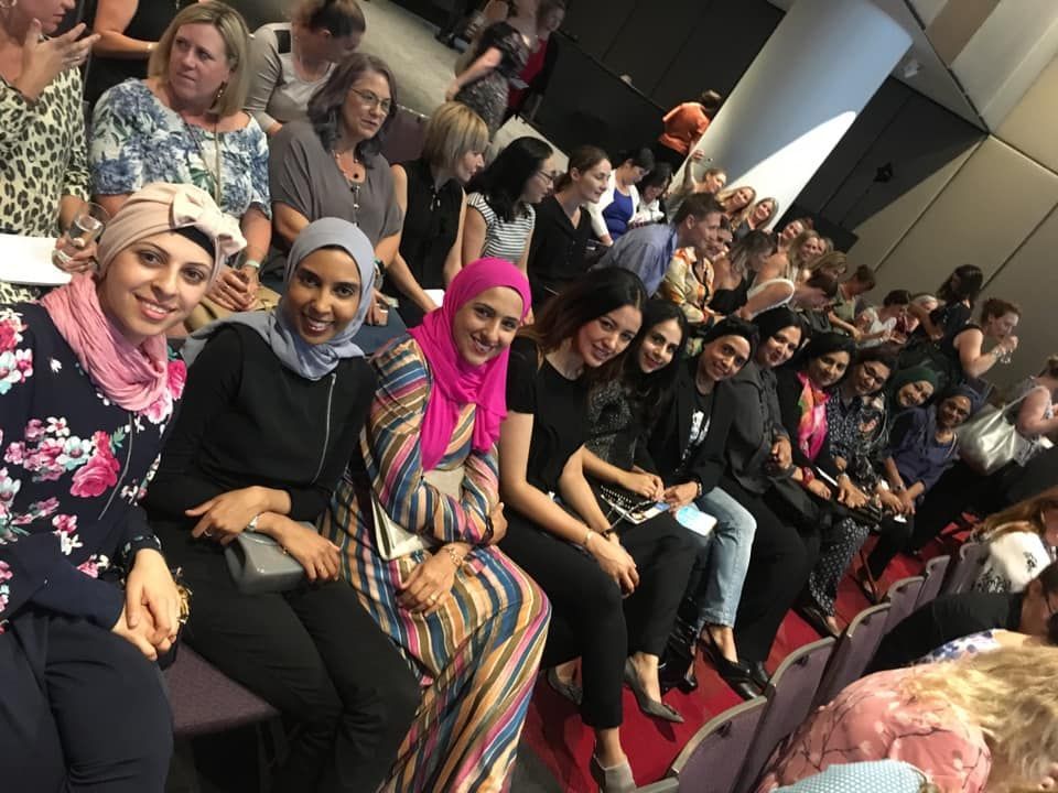 A group of women are sitting in chairs in a room.