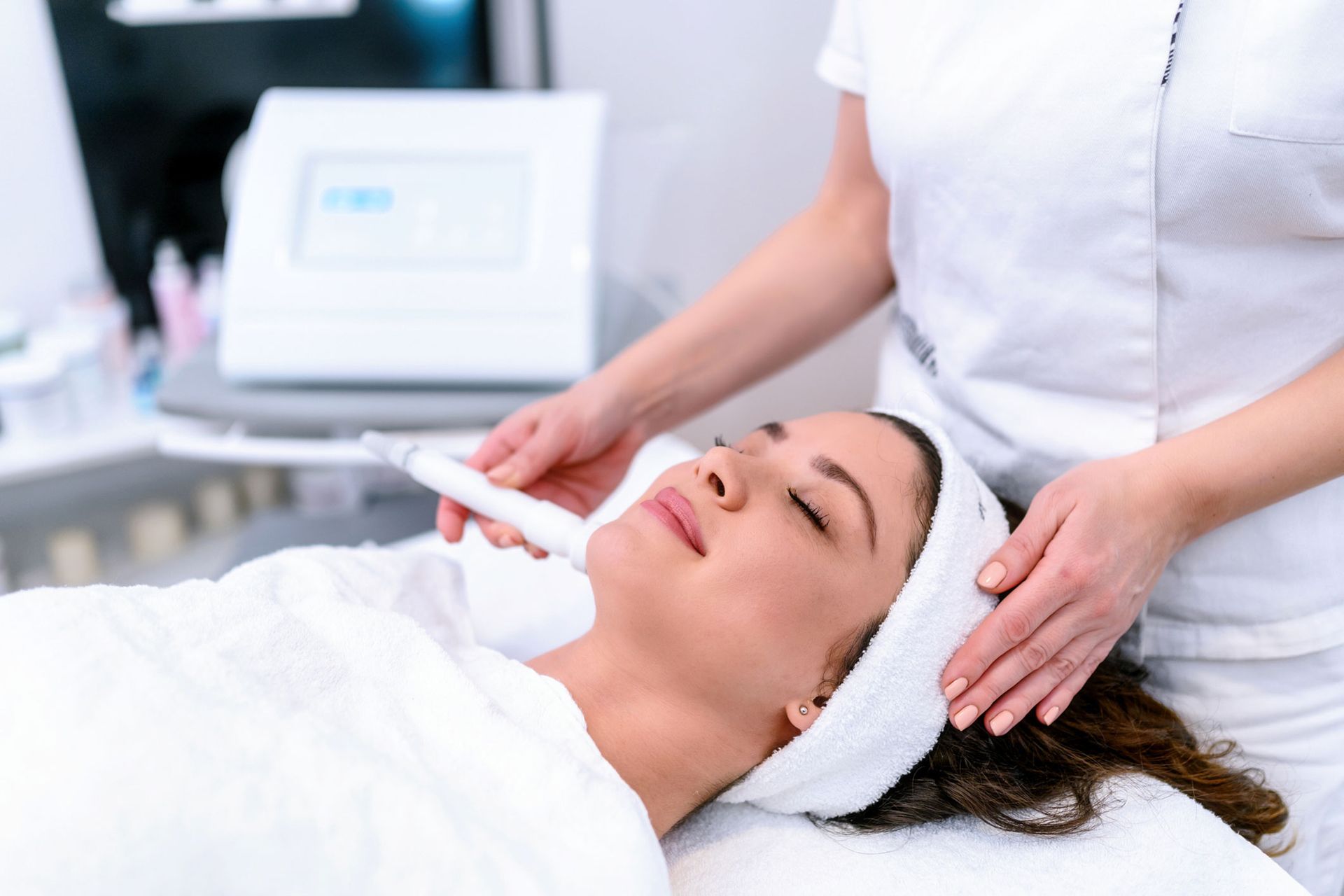 A woman is getting an ultrasonic treatment on her face