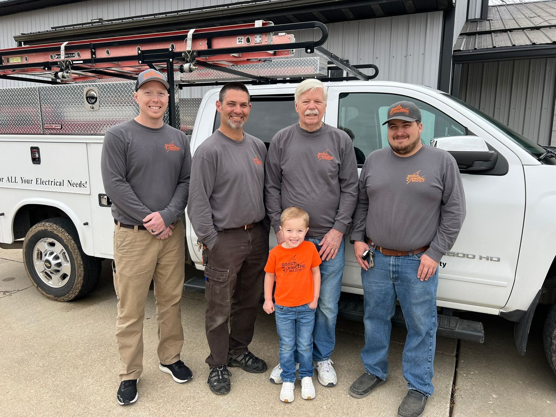 The Gooch family posing in front of the company truck