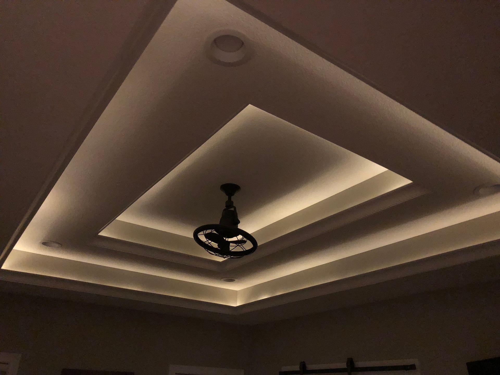 A ceiling fan is hanging from the ceiling in a dark room.