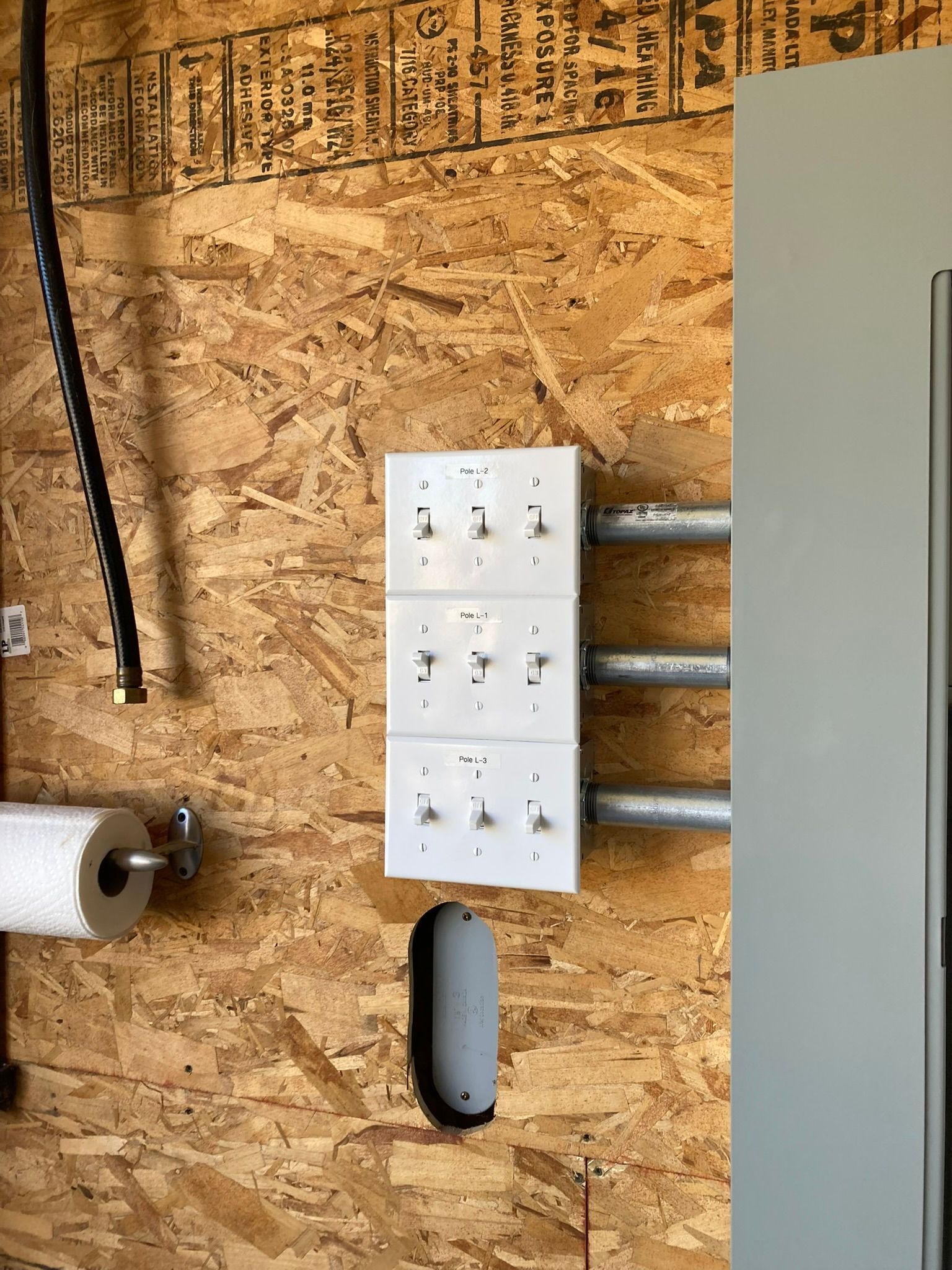 A wall with three electrical outlets and a paper towel holder.