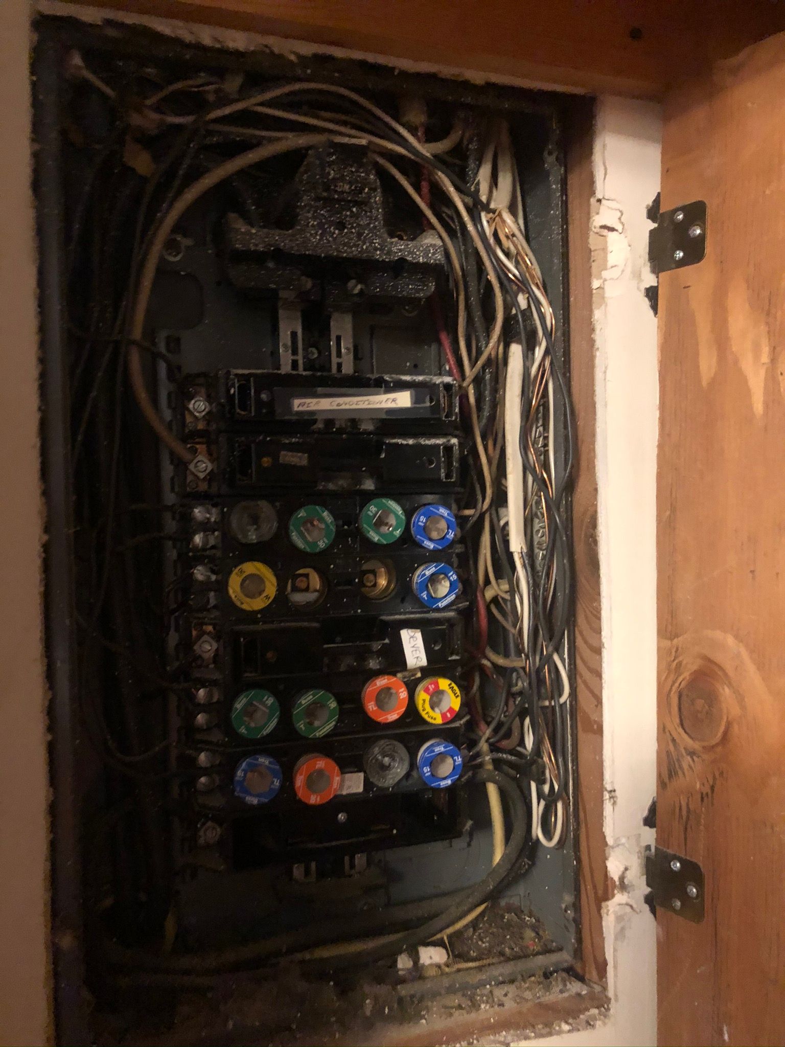 A very old electrical box with a lot of wires coming out of it.