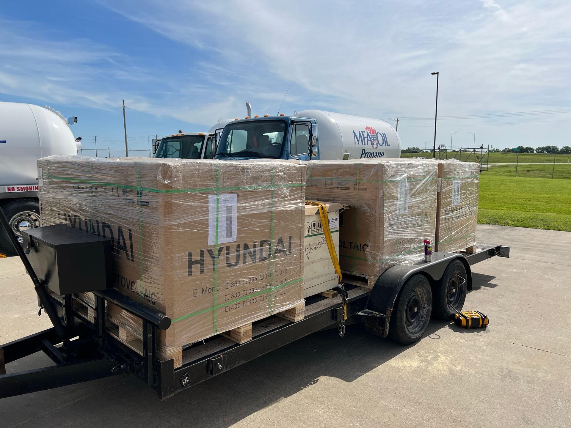 A trailer with boxes on it is parked on the side of the road.