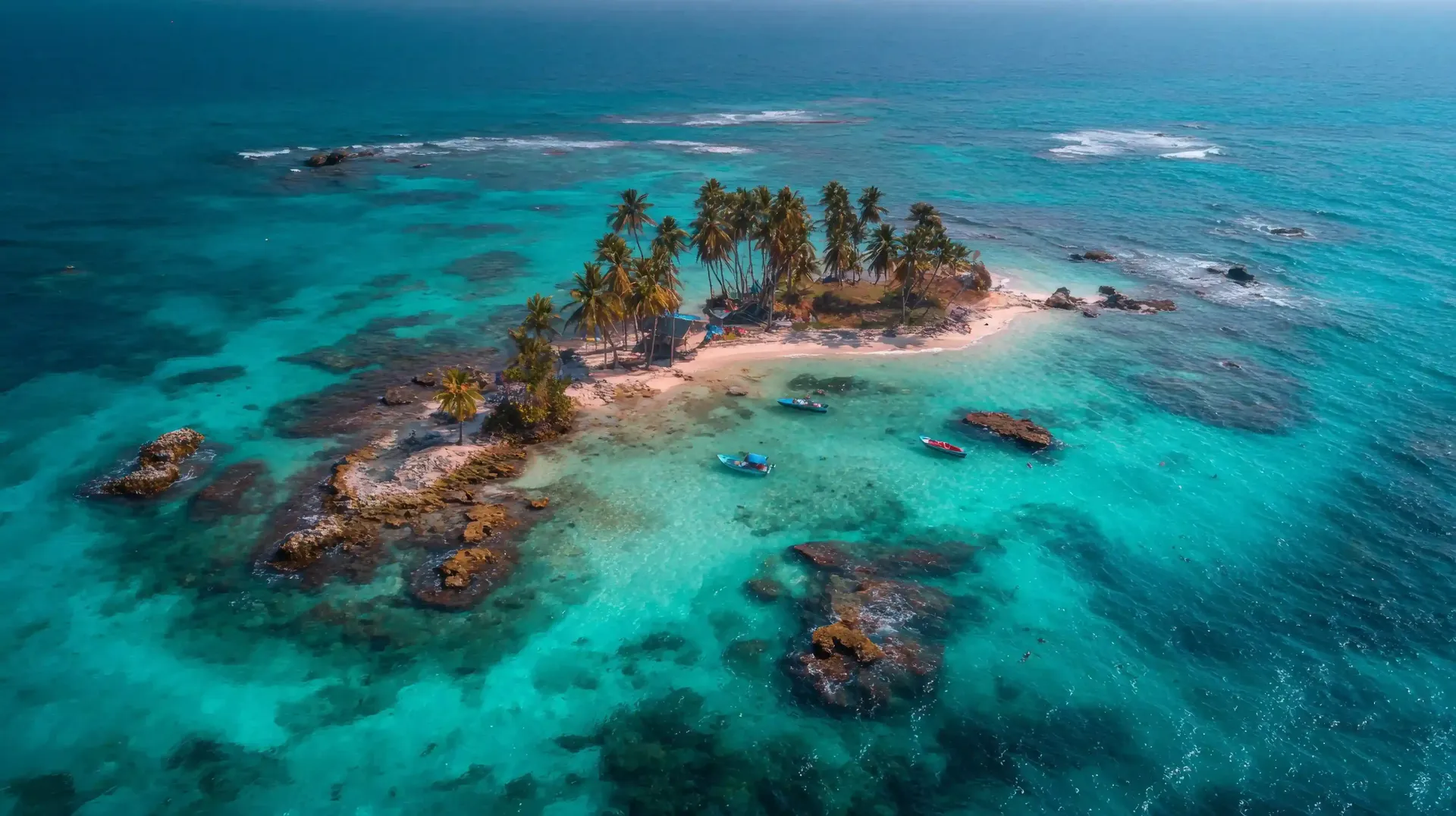 Vista aérea de corales y tonos turquesa en playas de San Andrés; atractivo natural del Caribe colombiano.