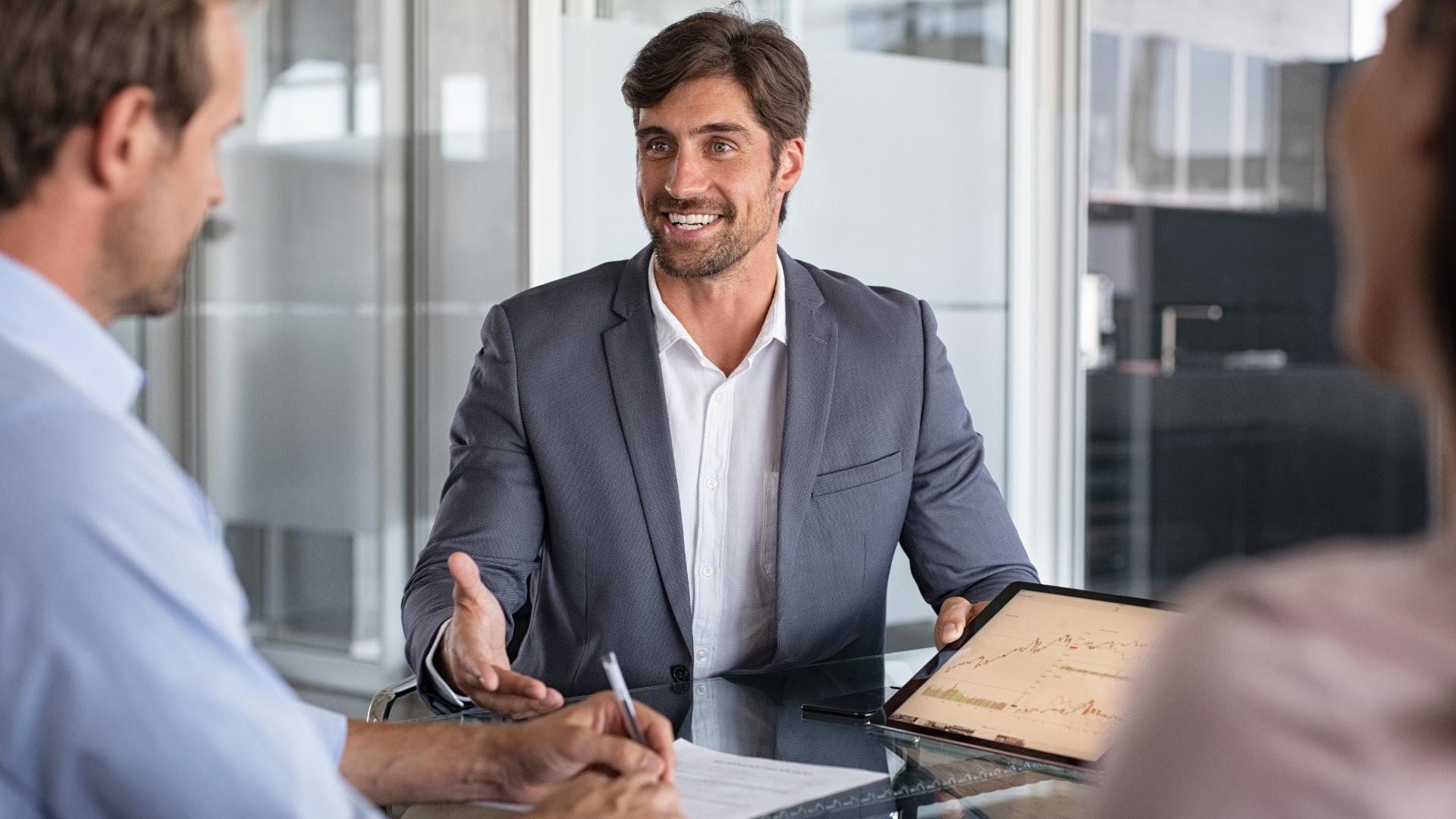 A man in a blue shirt and tie is using a laptop computer.