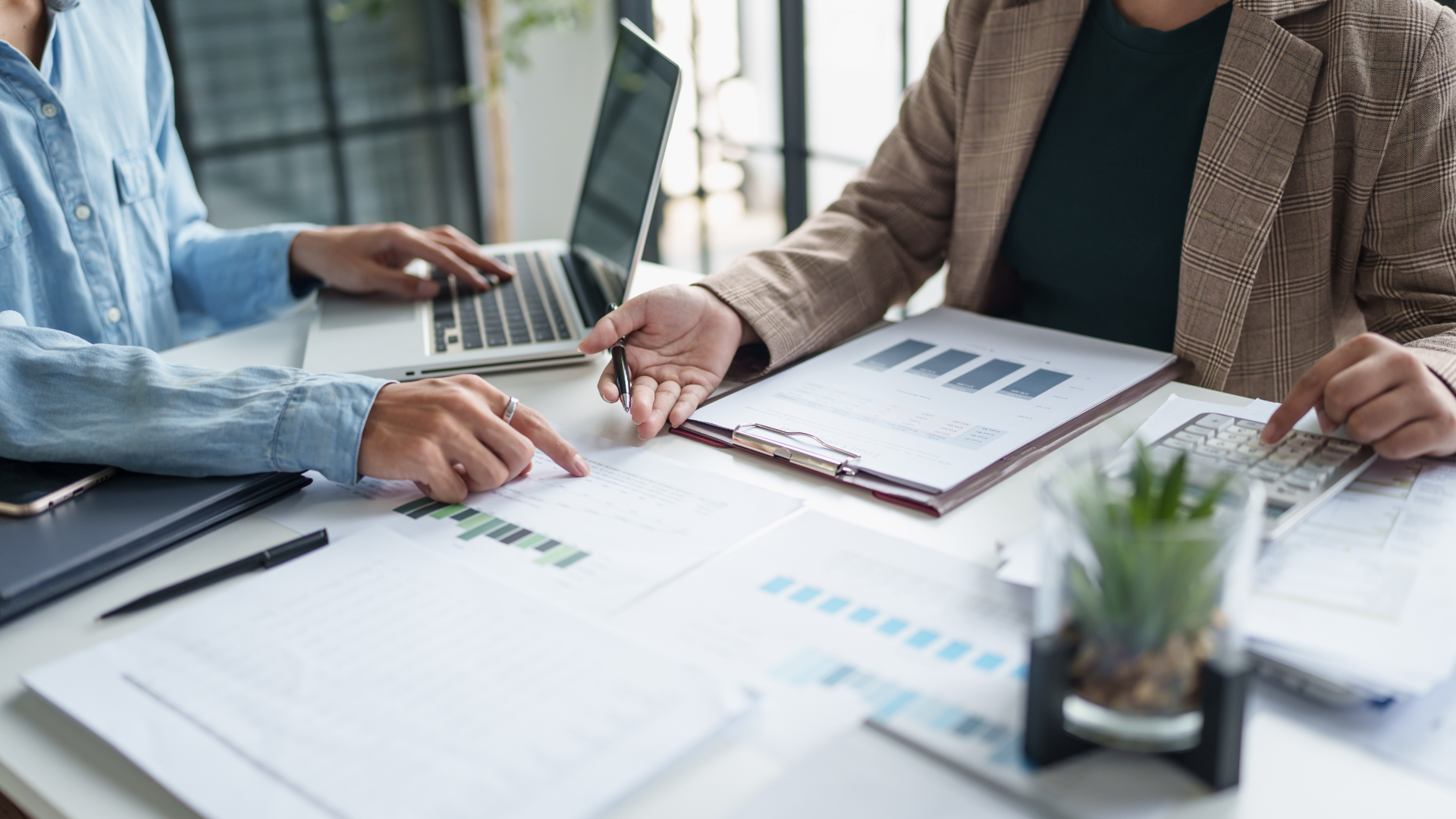 A man in a blue shirt and tie is using a laptop computer.