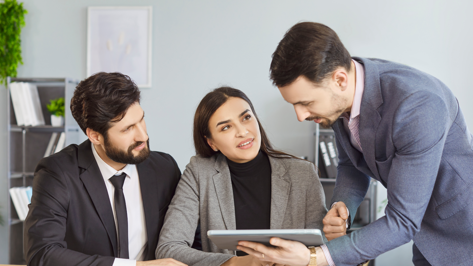 A man in a blue shirt and tie is using a laptop computer.