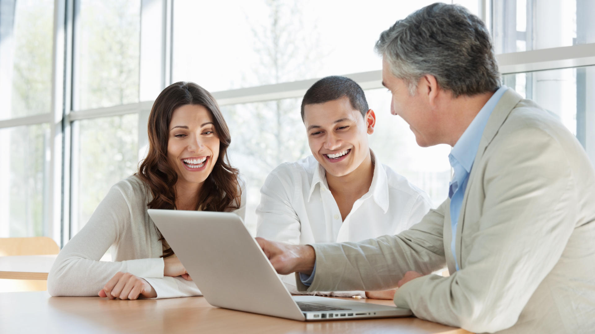 A man in a blue shirt and tie is using a laptop computer.
