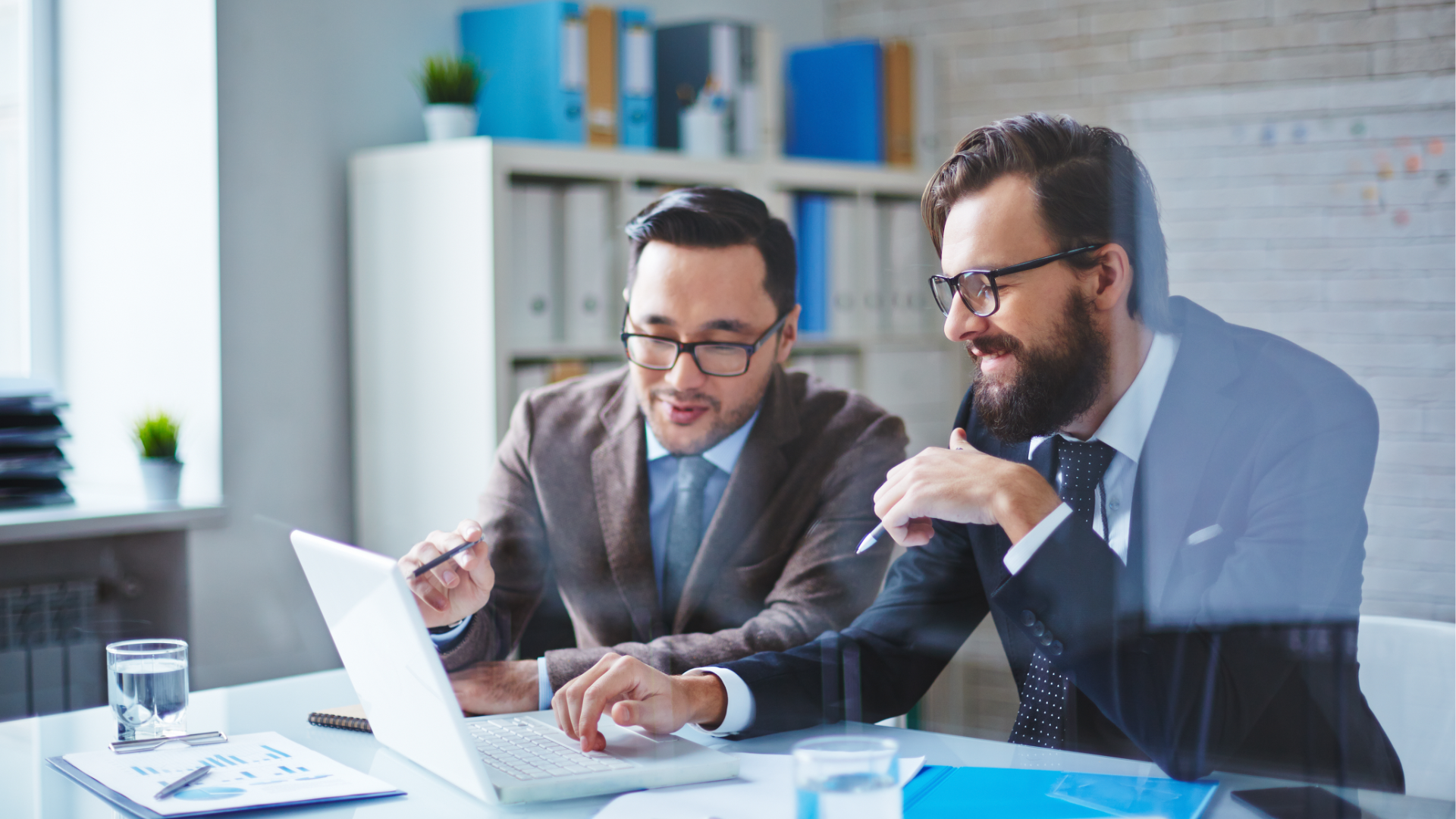 A man in a blue shirt and tie is using a laptop computer.