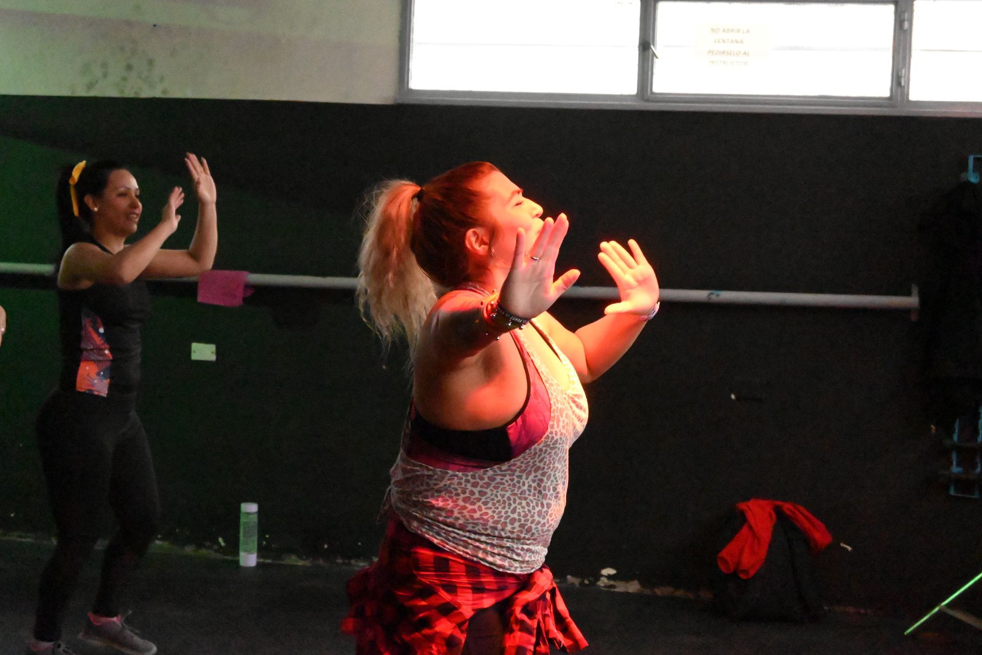 Un grupo de mujeres están bailando en un gimnasio.