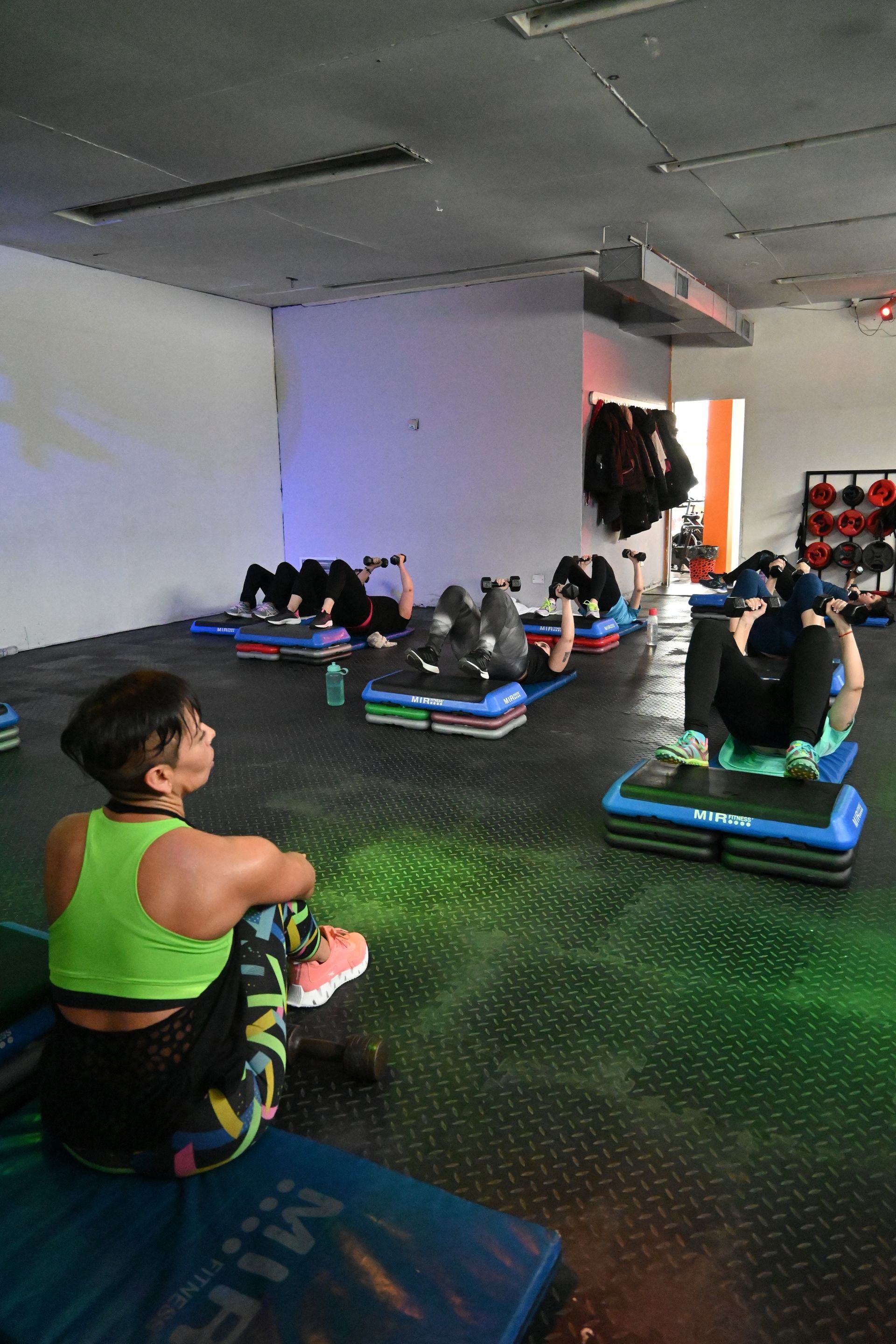 Un grupo de personas está haciendo ejercicios en un gimnasio.