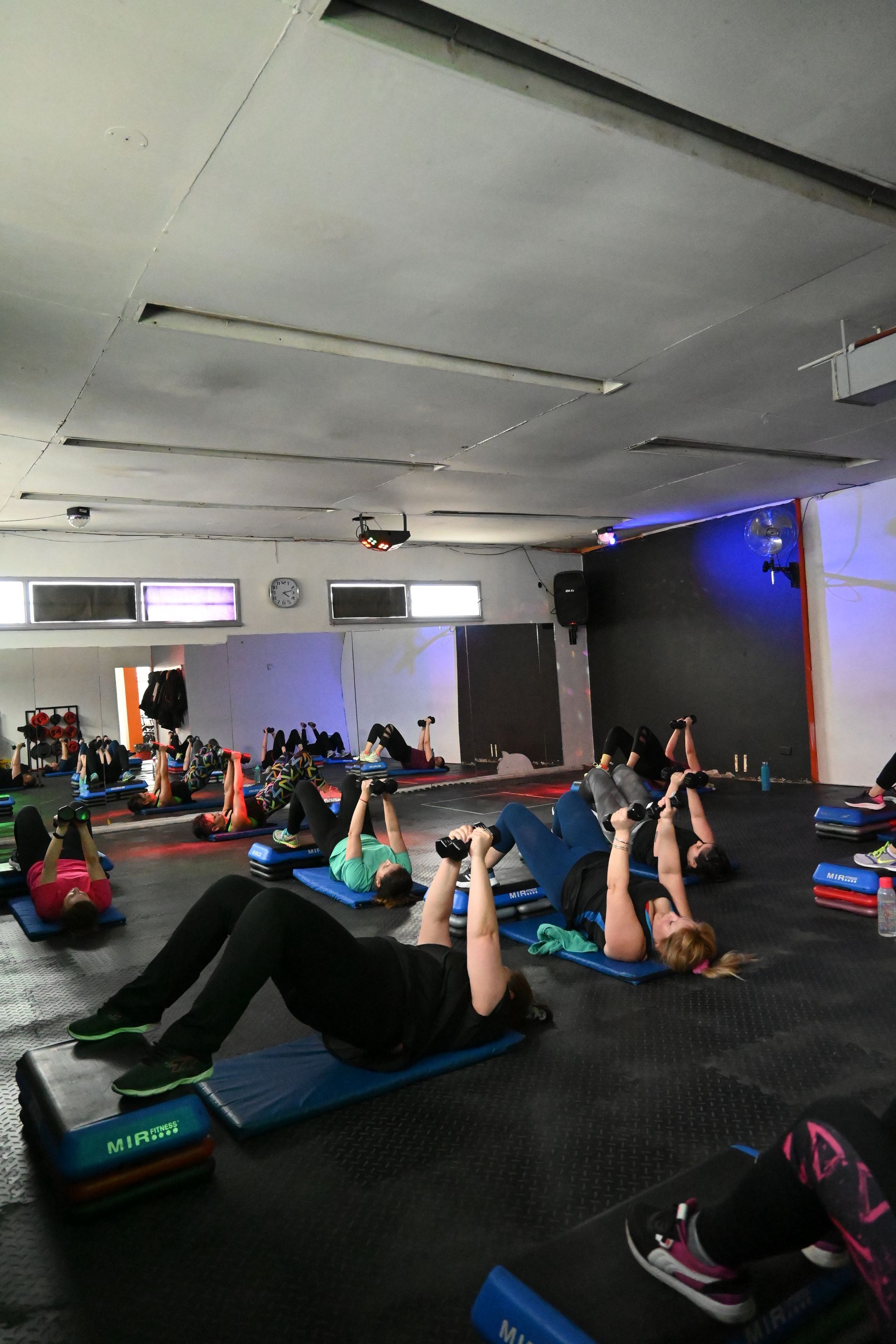 Un grupo de personas está haciendo ejercicios en un gimnasio.