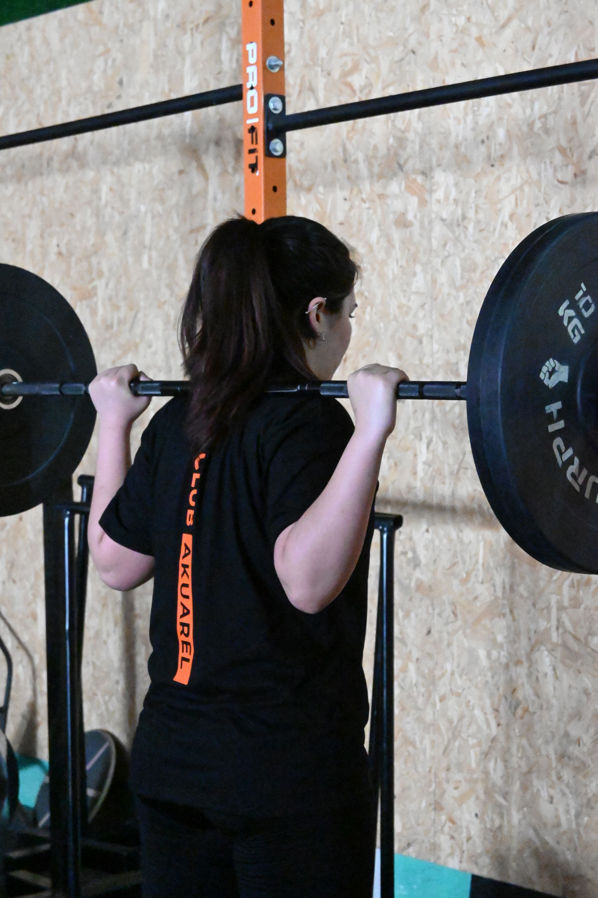 Una mujer en cuclillas con una barra que dice 