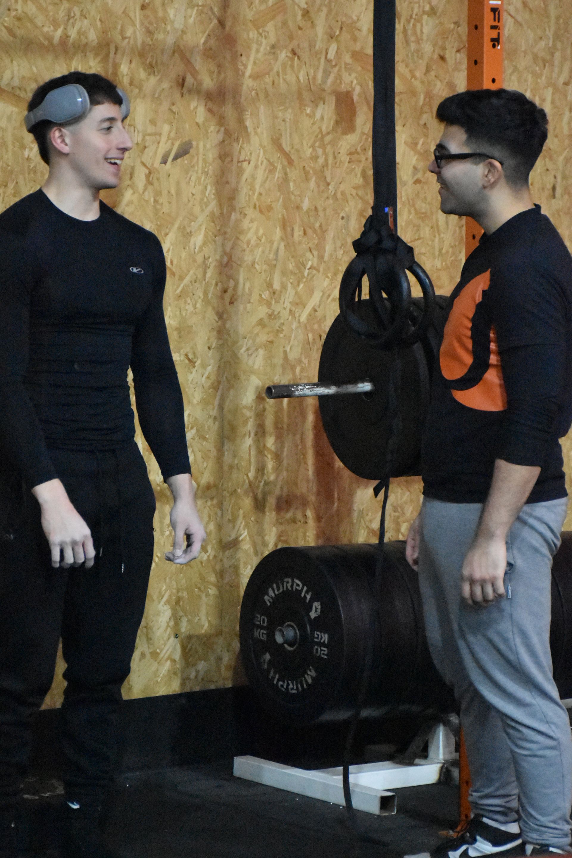 Dos hombres están parados uno al lado del otro en un gimnasio.