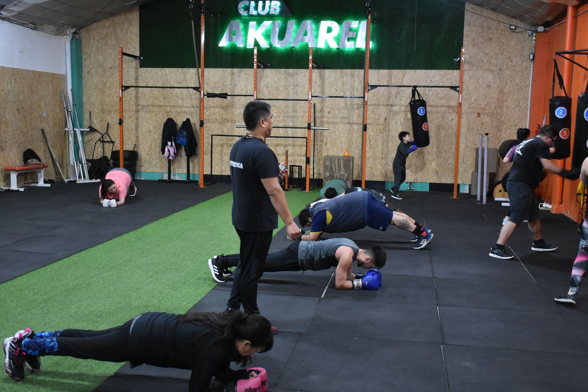 Un grupo de personas está haciendo flexiones en un gimnasio.