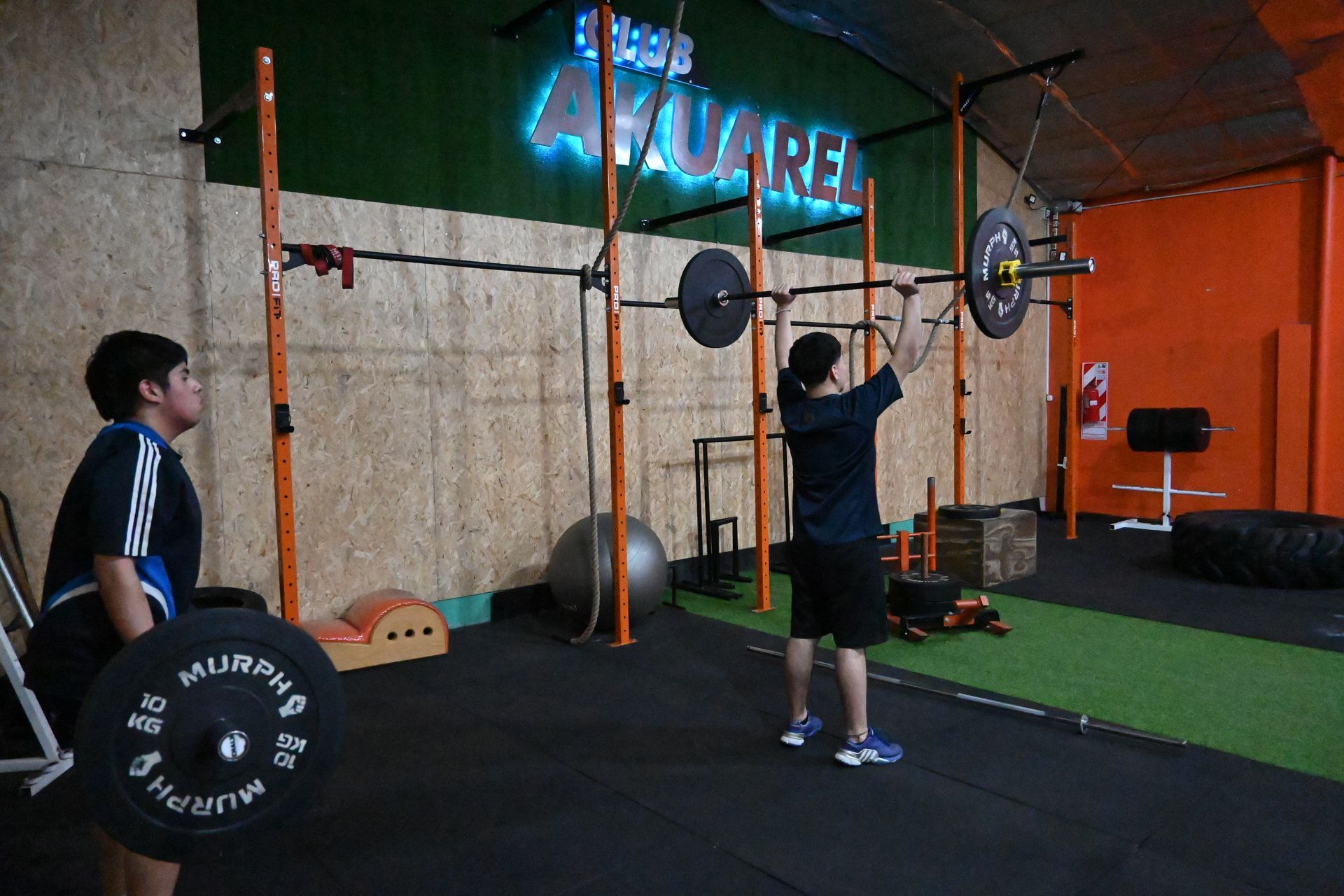 Un hombre está levantando una barra en un gimnasio.