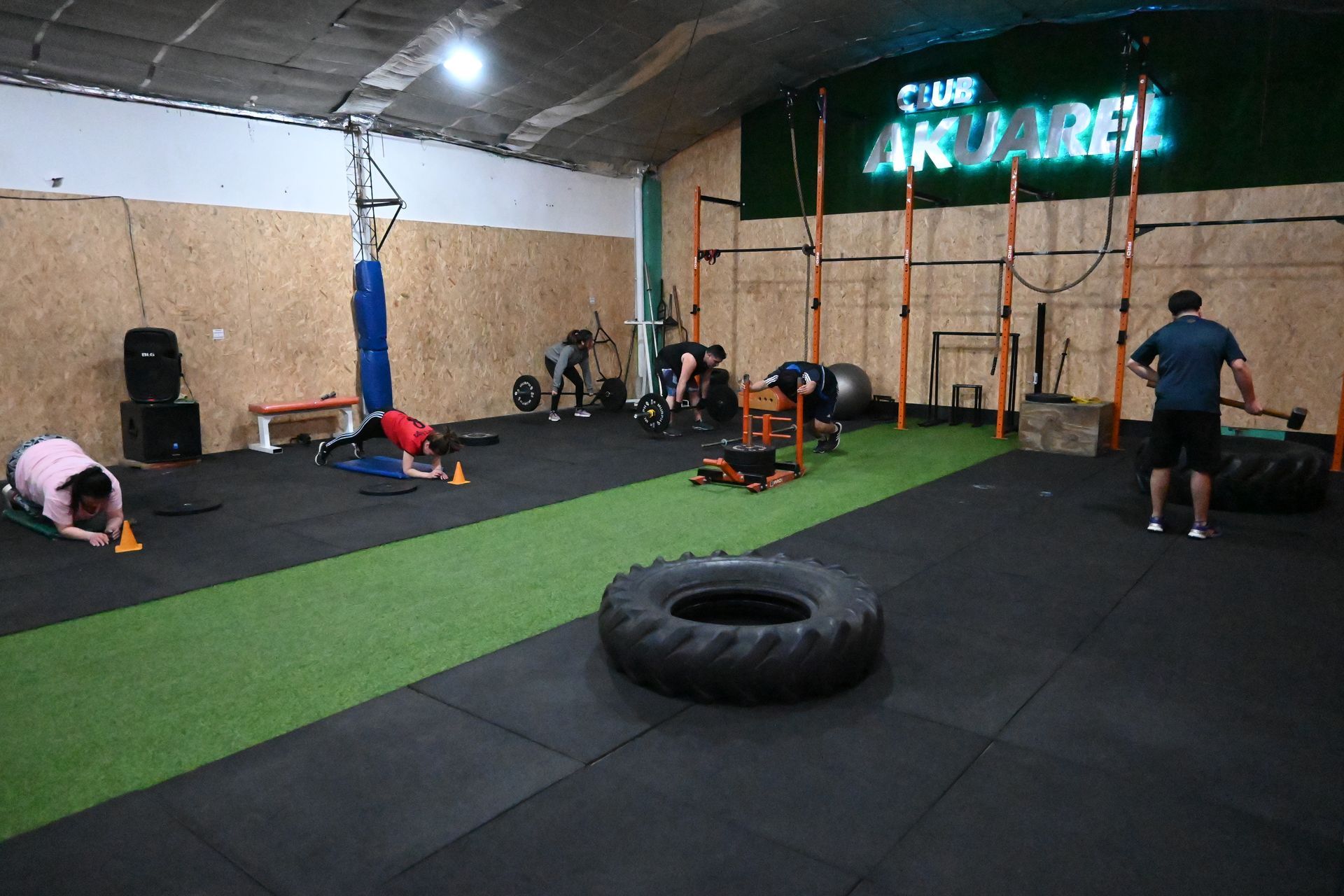 Un grupo de personas está haciendo flexiones en un gimnasio.