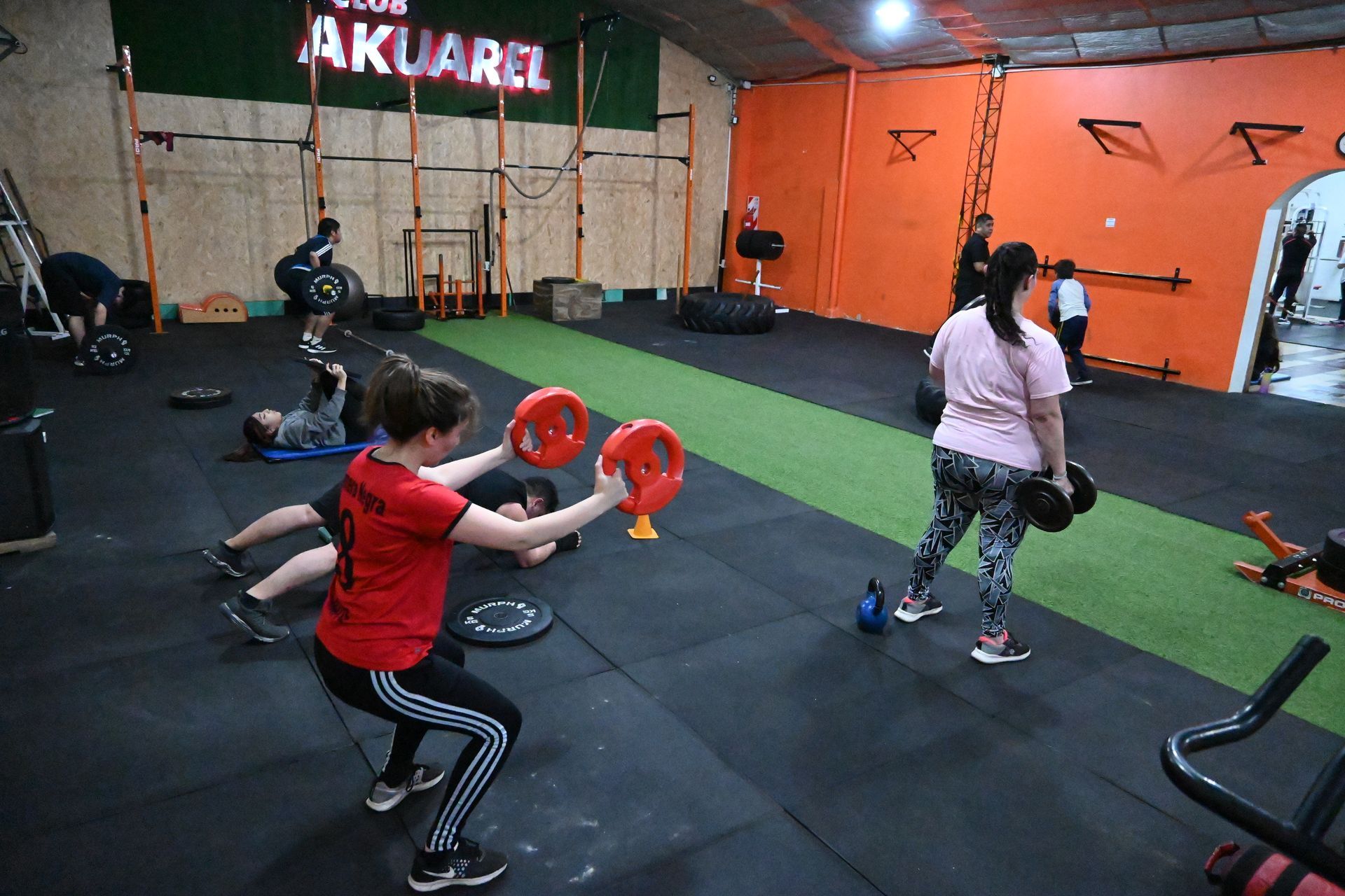 Un grupo de personas está haciendo ejercicios en un gimnasio.