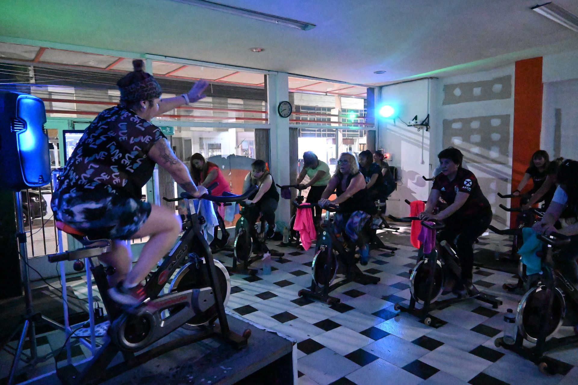Un grupo de personas está montando bicicletas estáticas en un gimnasio.
