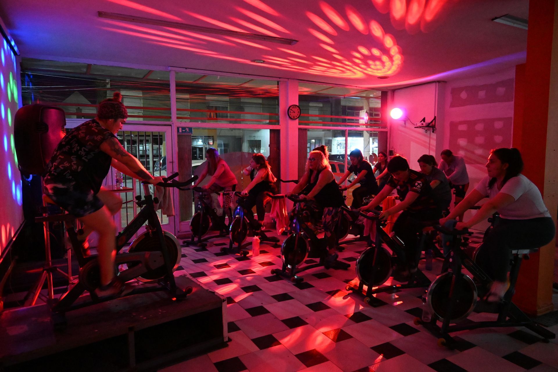 Un grupo de personas está montando bicicletas estáticas en un gimnasio.