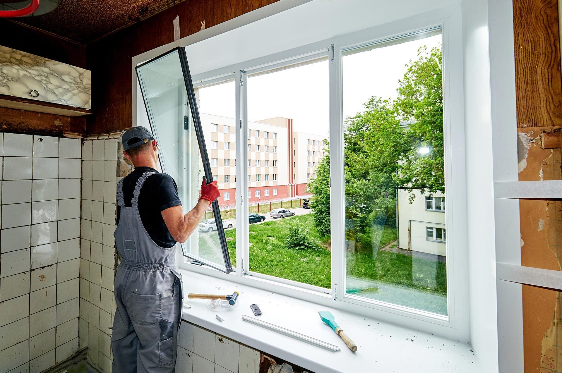 A man is replacing a window in a house.