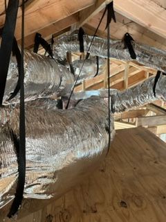 A bunch of ducts are hanging from the ceiling of a building.