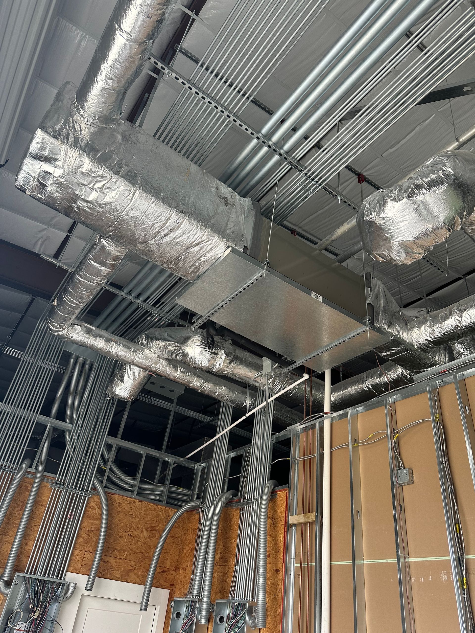 A building under construction with a lot of wires hanging from the ceiling.