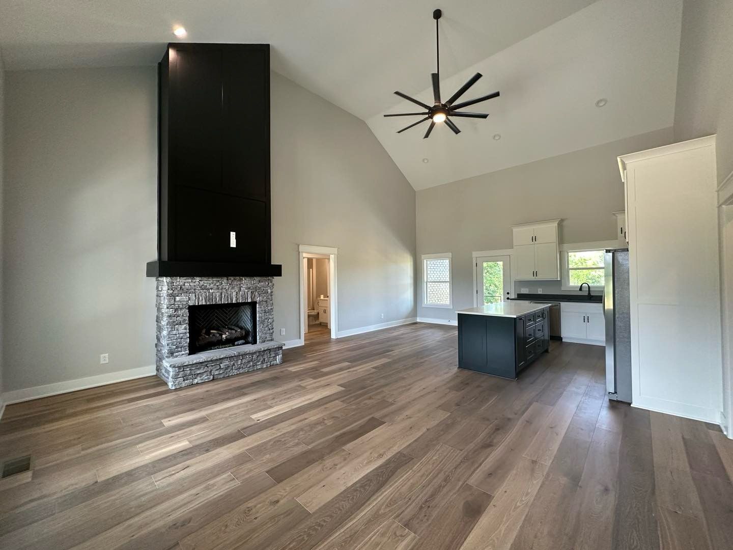 A living room with a fireplace and a ceiling fan