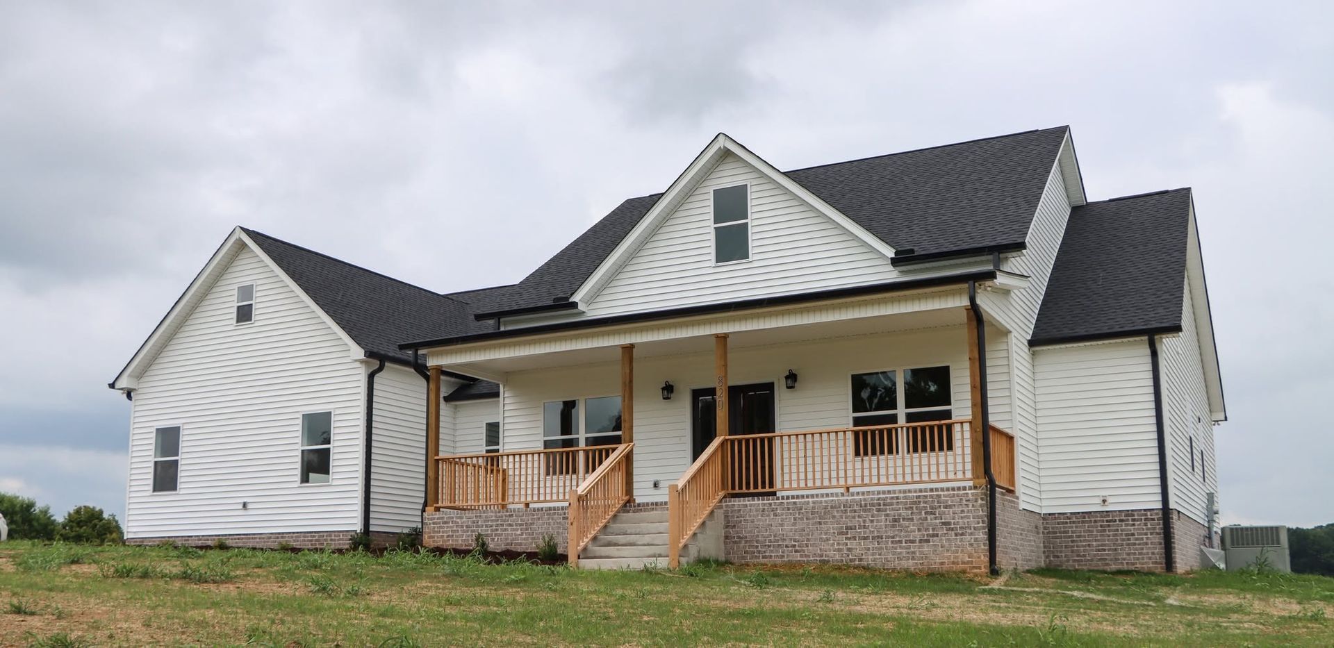 A large white house with a black roof and a porch