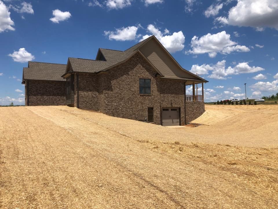 A large house is sitting in the middle of a field.