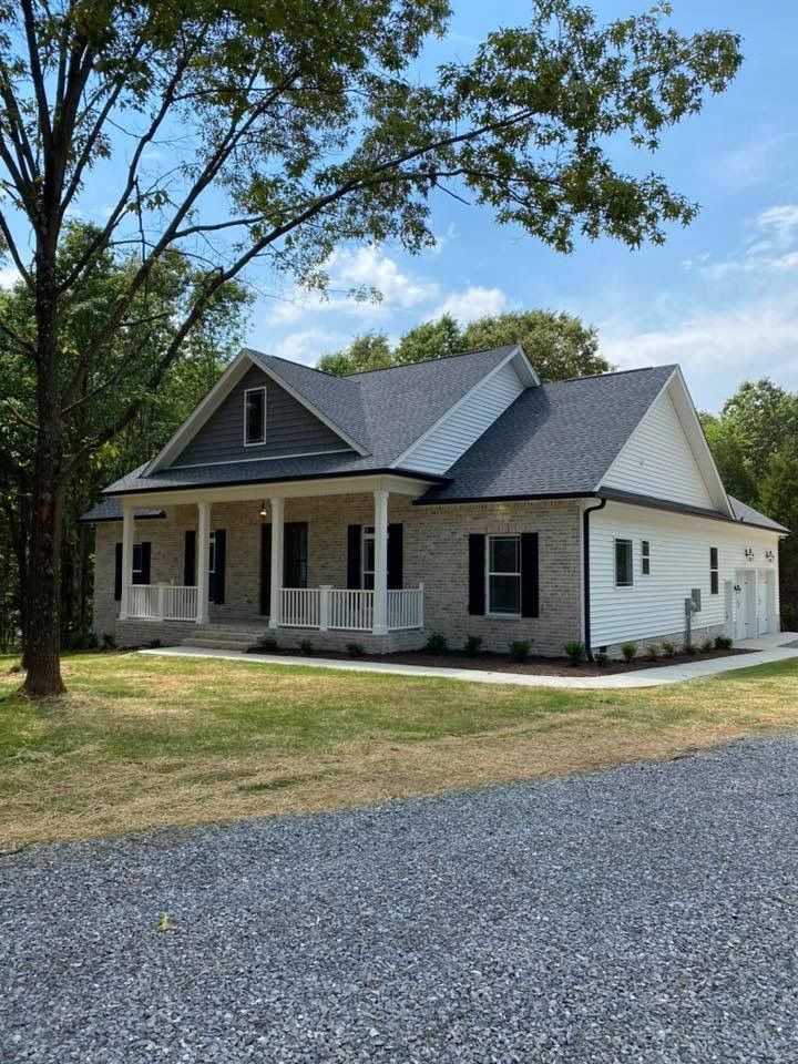 A white house with a gray roof and a porch