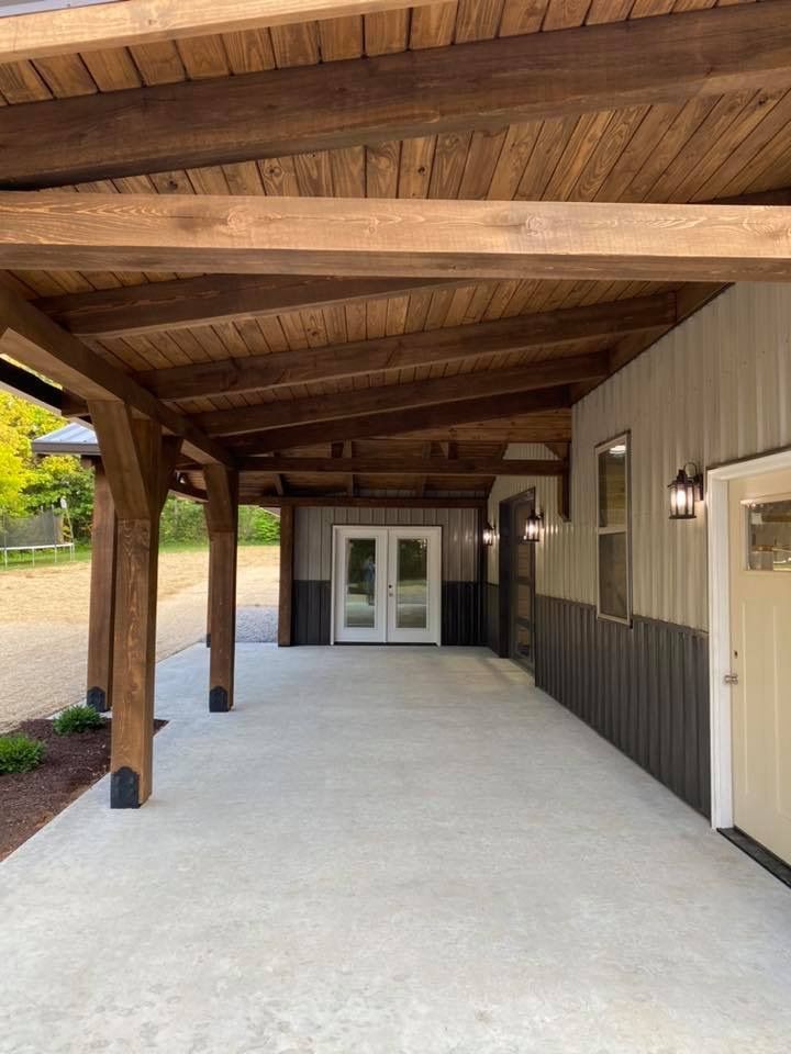 A covered walkway leading to a house with a wooden roof.