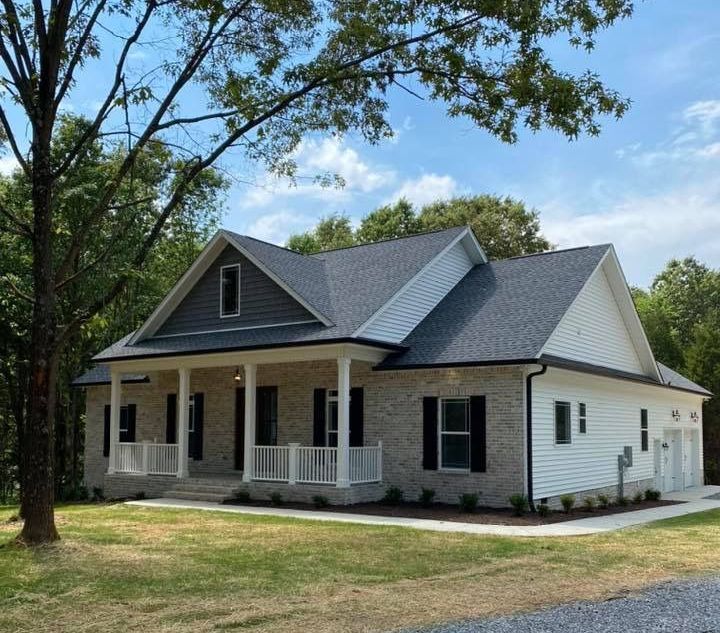 A white house with a gray roof and black shutters