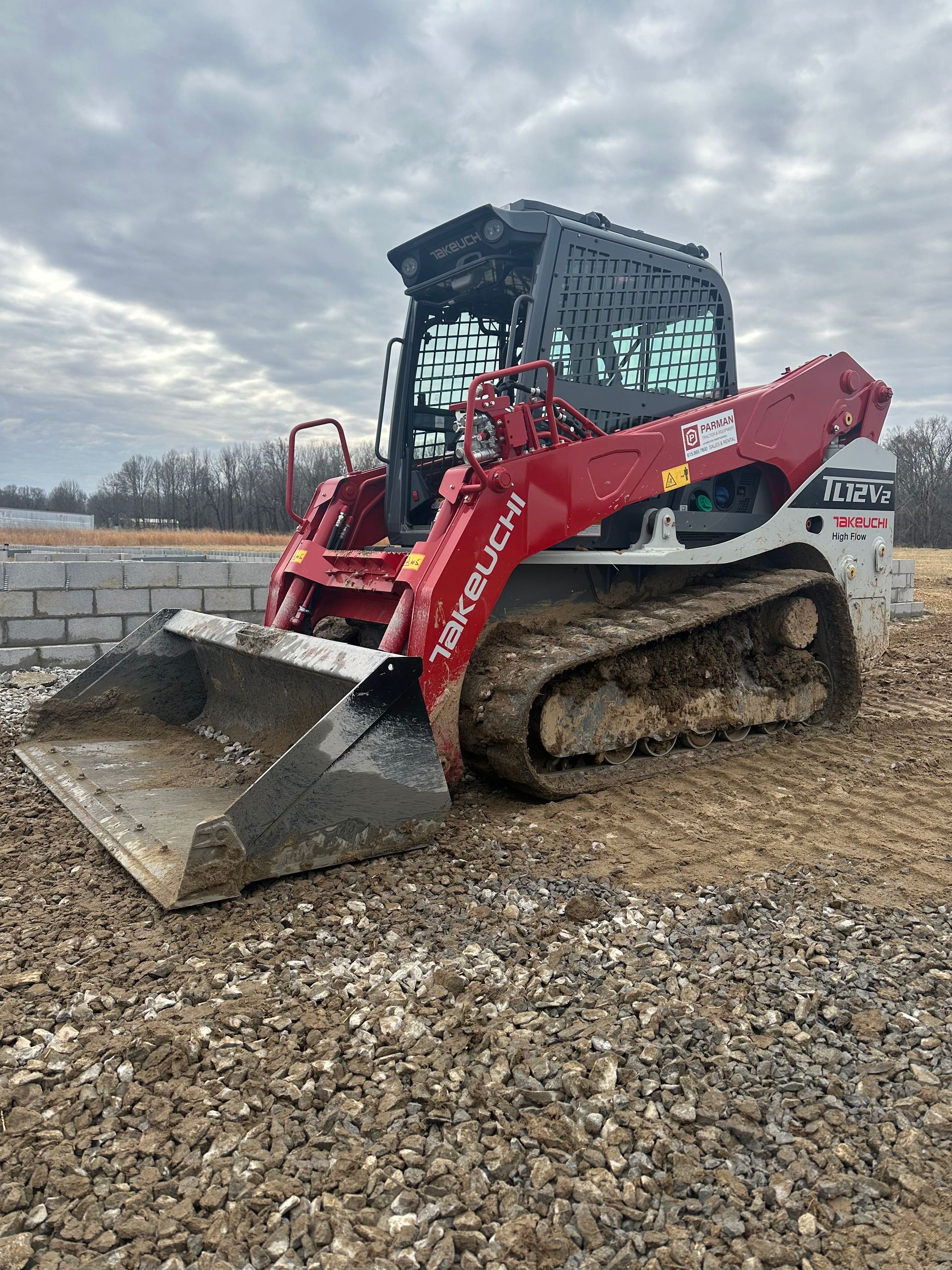 A bulldozer is sitting on top of a gravel field.