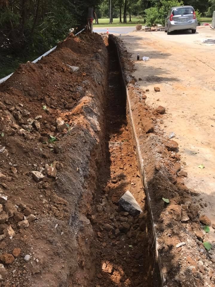 A car is parked on the side of the road next to a large pile of dirt.