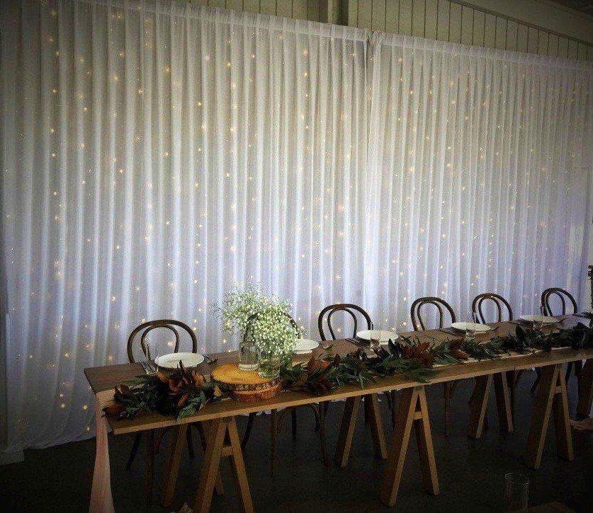 White Fairylight Curtain shown with white chiffon drapes and white wall wash lights on either side, 9m wide from $500 incl installation, pick up & gst