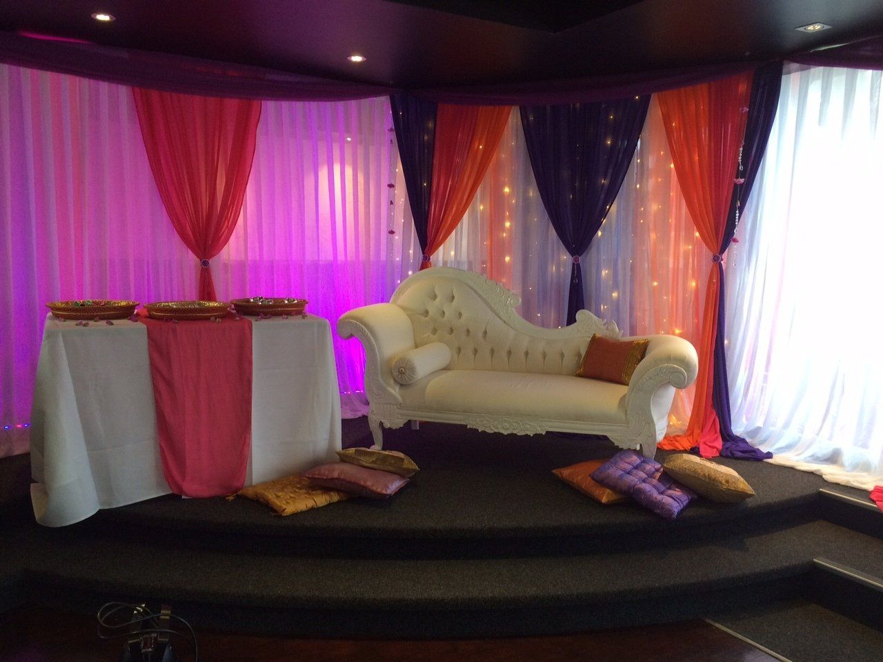 Bespoke fairy curtain with purple, pink and orange wall draping and coloured lighting for henna night at Bollywood restaurant Auckland
