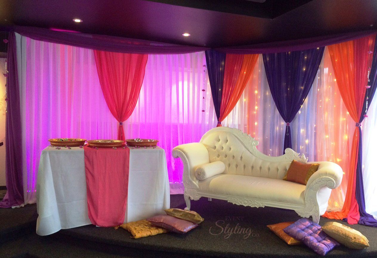 Bespoke wall draping with lighting and flowers suspended from ceiling for a clients Mehndi night (Henna night) at Bollywood Resturant