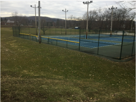 A tennis court with a green fence around it