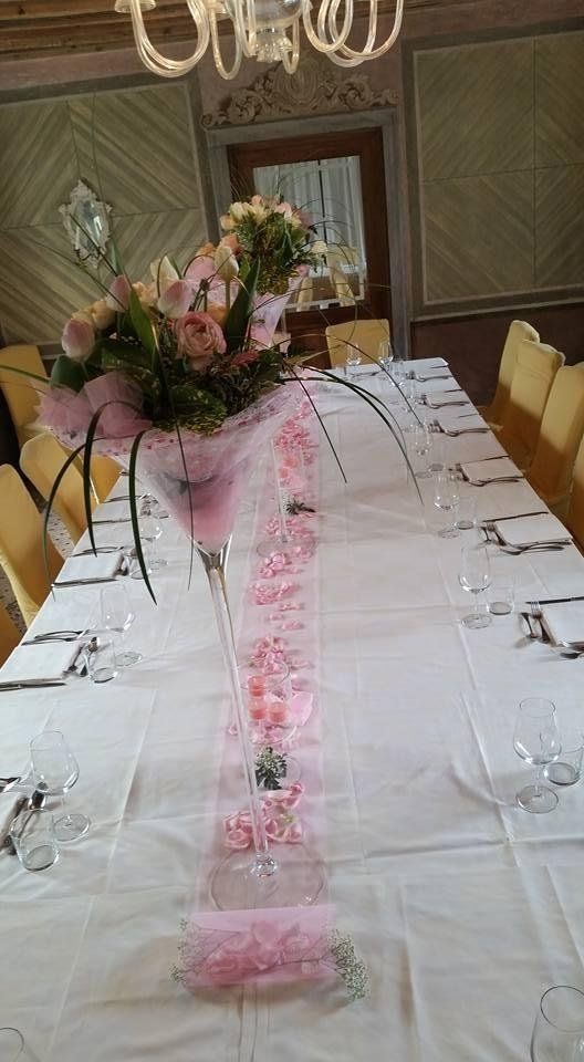 Allestimento di tavolo con vasi di fiori e decorazioni rosa