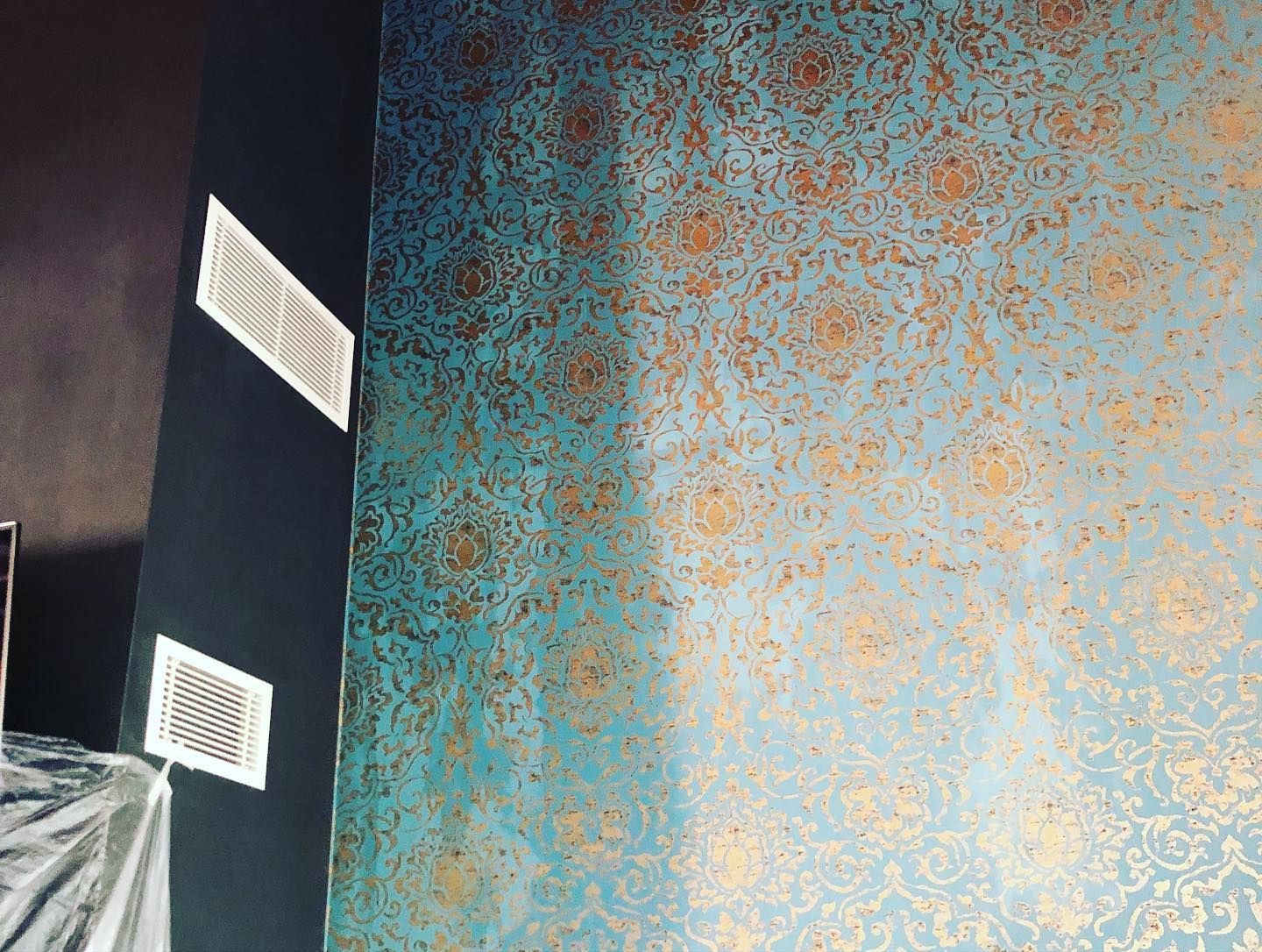 Carta da parati con motivi blu e oro su un angolo della parete