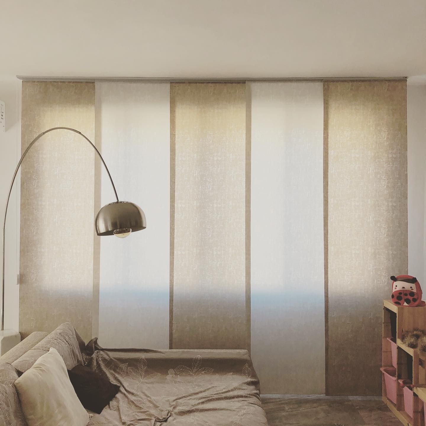 Due poltrone in velluto blu con braccioli angolari sono appoggiate su un pavimento in legno. Una ha un cuscino coordinato.