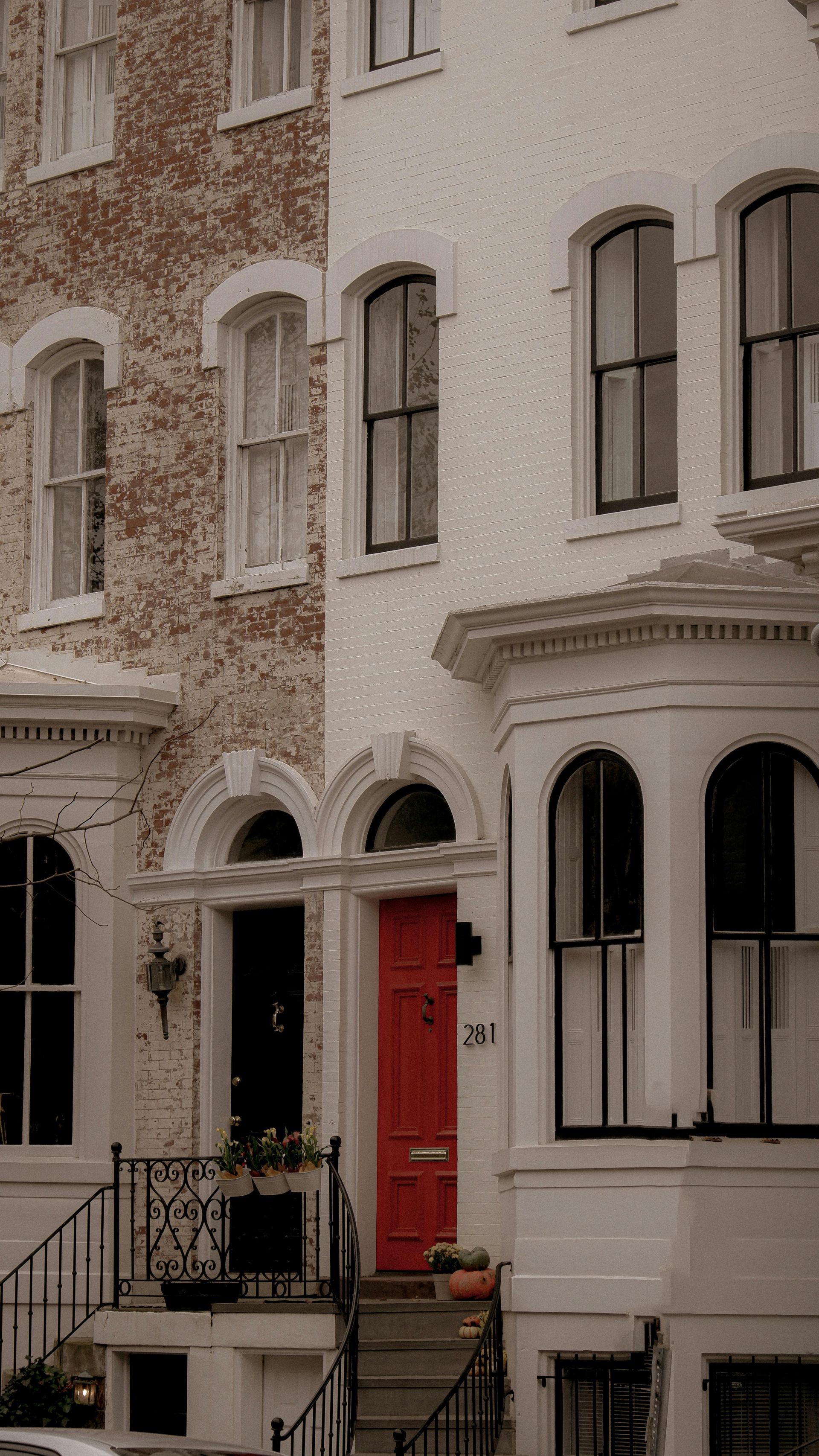 A row of buildings with a red door and stairs.