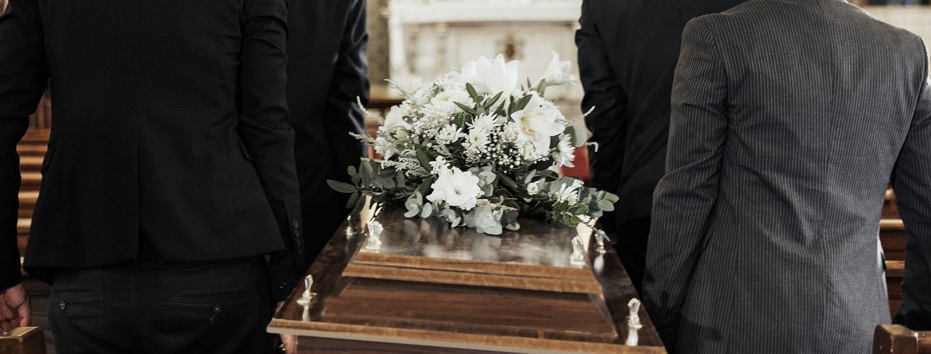 a group of people are carrying a coffin in a church .